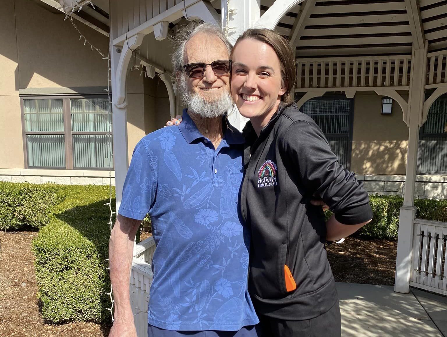 Resident and staff member smiling