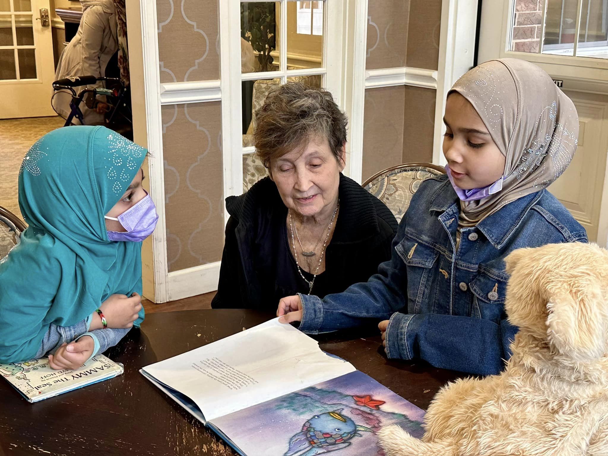Churchill Place resident and two children reading