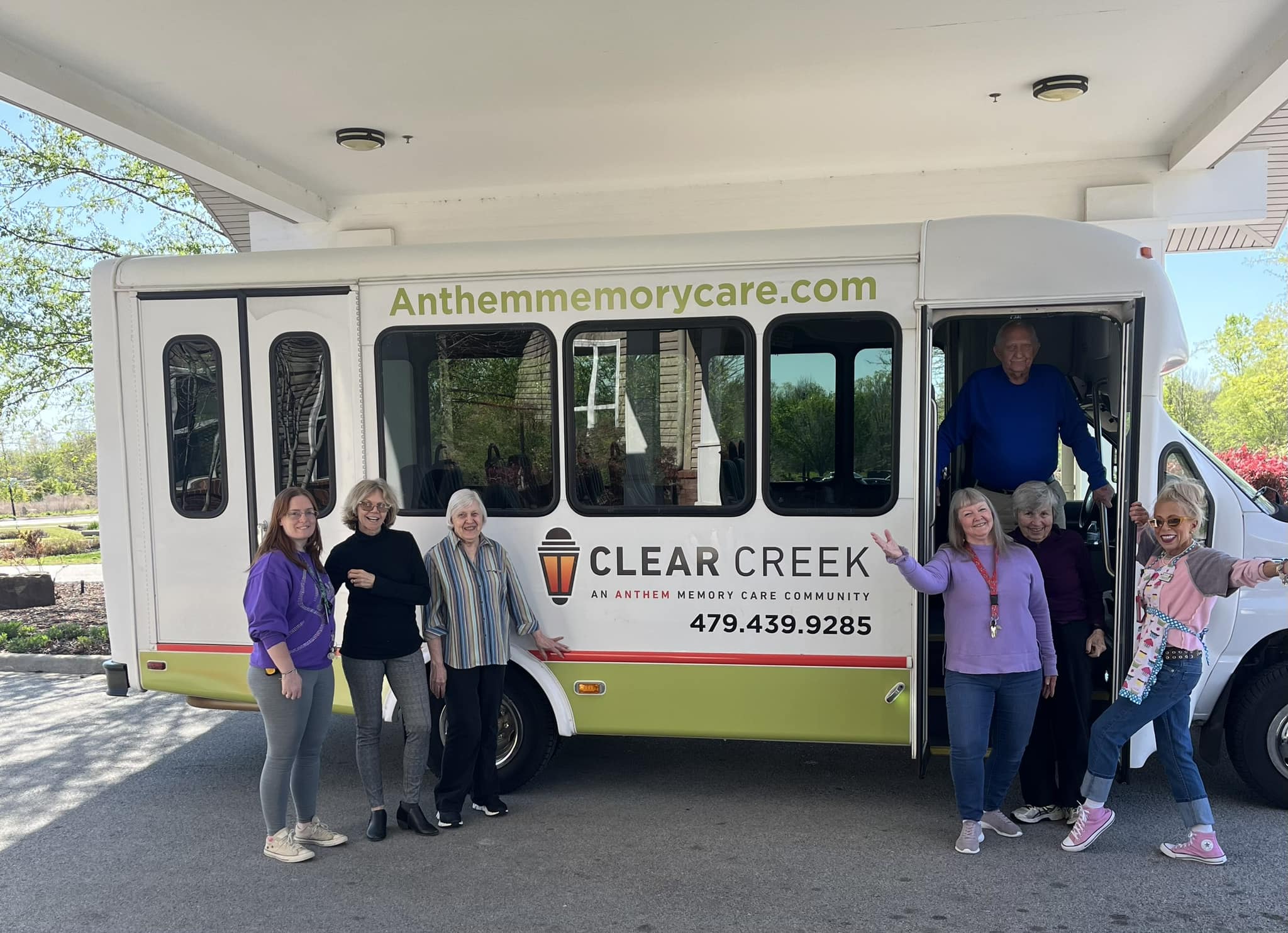 Residents posing in front of the Clear Creek bus
