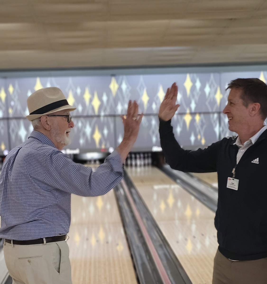 Resident and staff high fiving during bowling