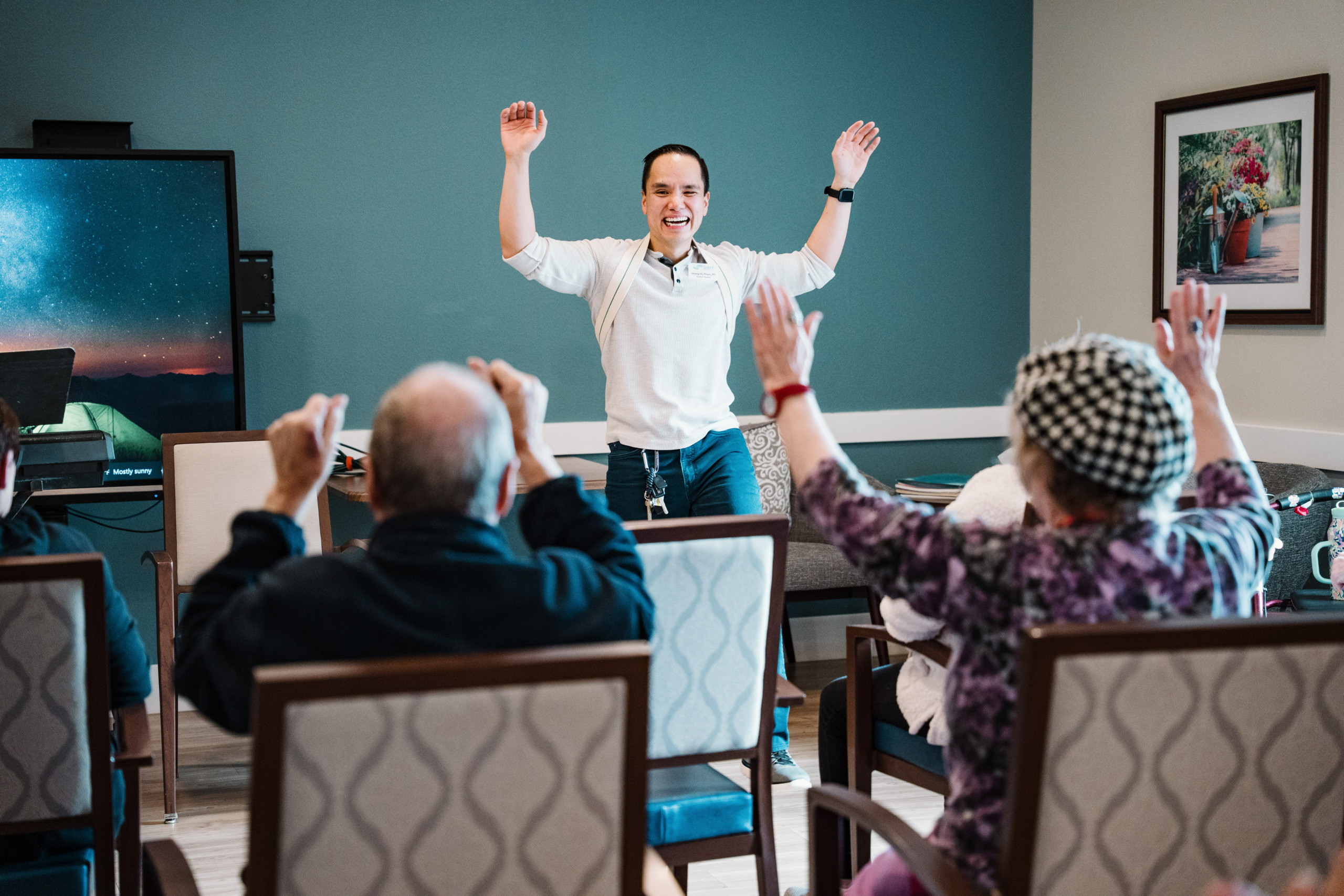 Our Physical Therapist is smiling and leading an exercise class.
