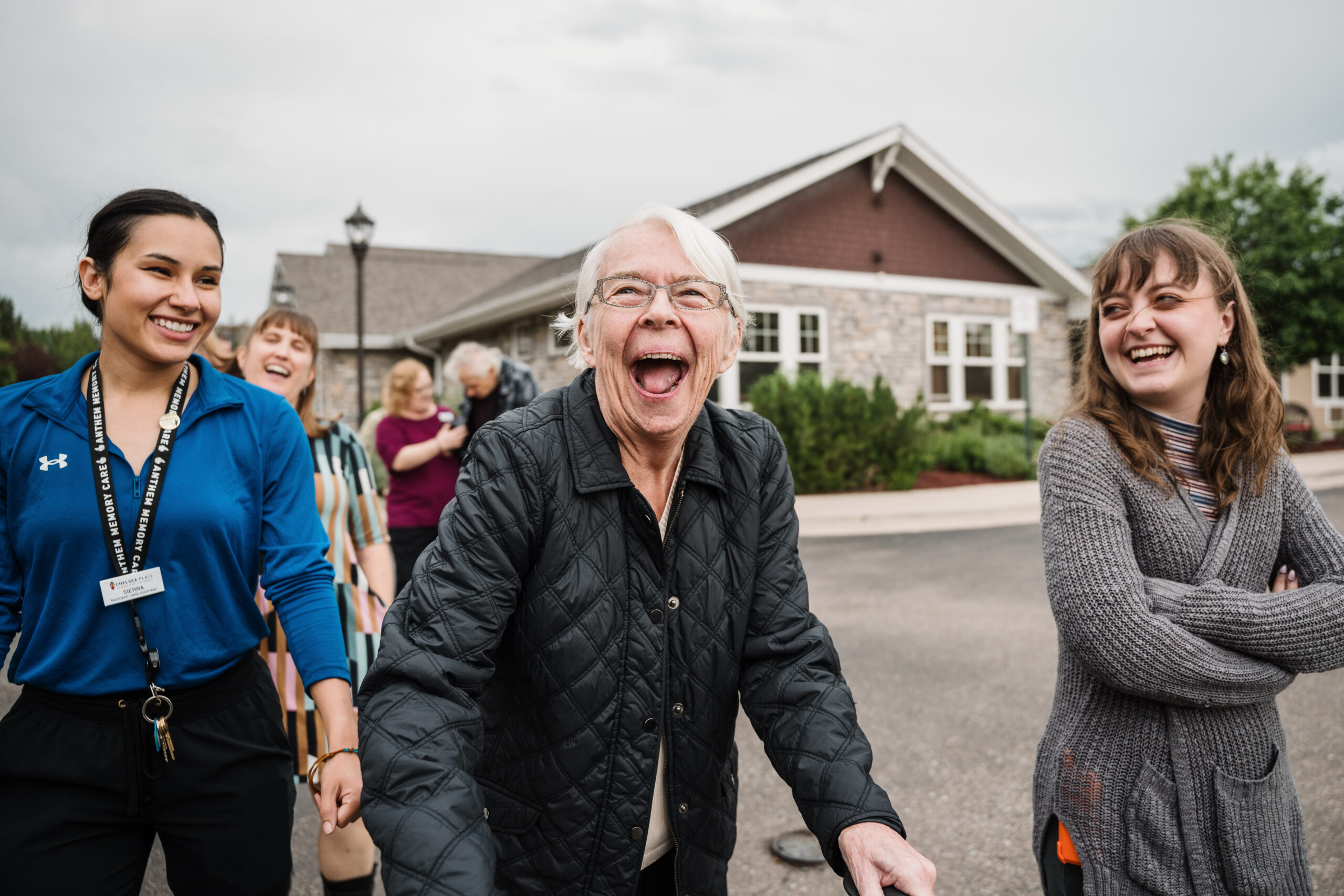 Resident and staff walking outside and laughing